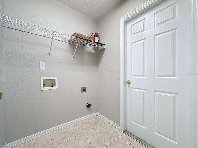 laundry area with washer hookup, hookup for an electric dryer, a textured ceiling, and light tile patterned flooring