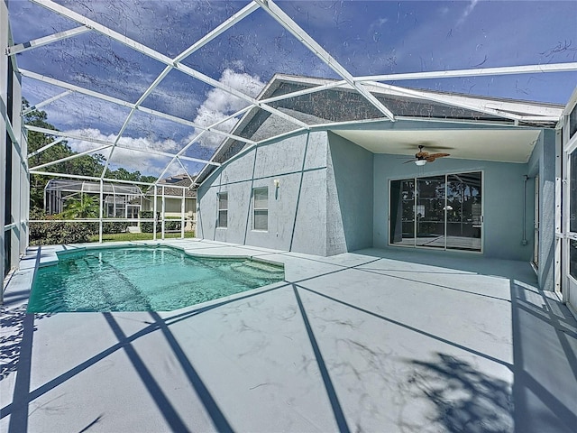 view of swimming pool featuring glass enclosure, a patio area, and ceiling fan