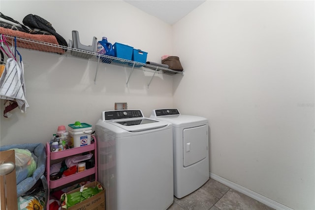 laundry area featuring light tile patterned flooring and washing machine and dryer