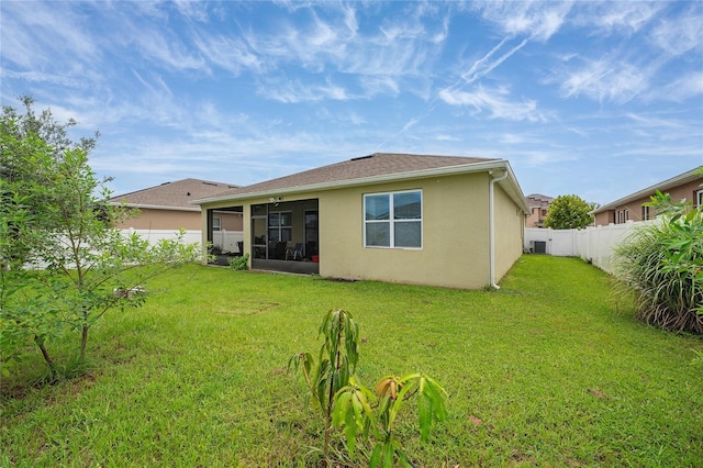 back of property featuring a yard and a sunroom