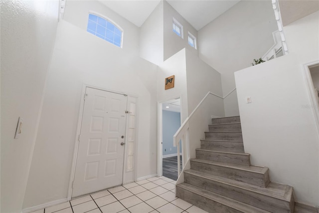 tiled entrance foyer with a towering ceiling