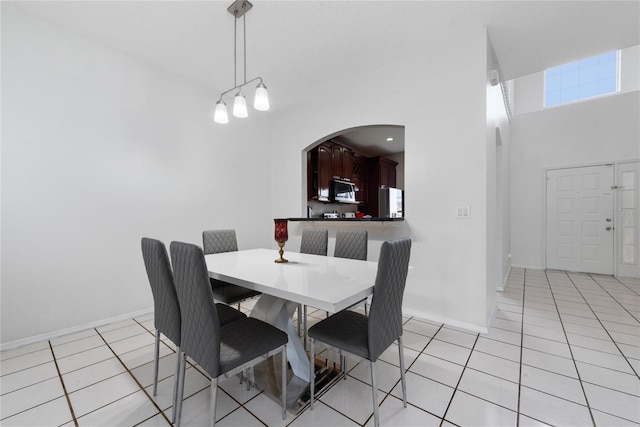 tiled dining area with a towering ceiling