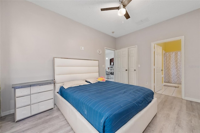 bedroom featuring ensuite bath, light hardwood / wood-style floors, and ceiling fan