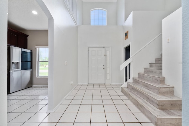 tiled entryway with a towering ceiling