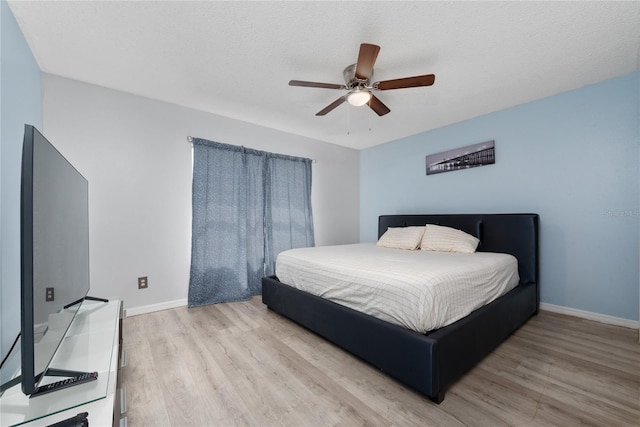 bedroom featuring a textured ceiling, light hardwood / wood-style floors, and ceiling fan