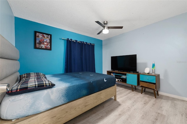 bedroom featuring ceiling fan, a textured ceiling, and light wood-type flooring