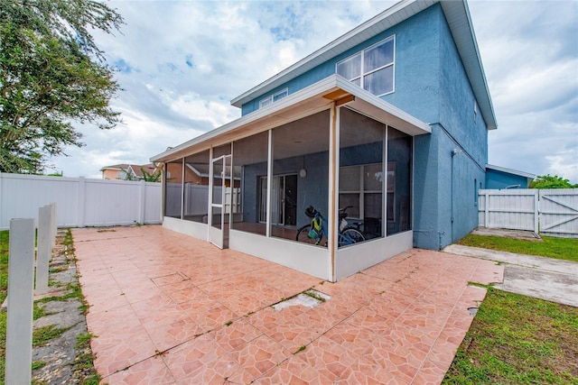 rear view of house featuring a patio area and a sunroom