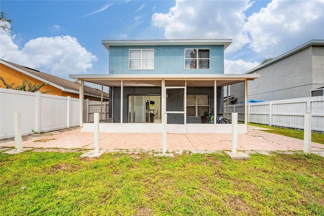 back of house featuring a patio area, a sunroom, and a lawn