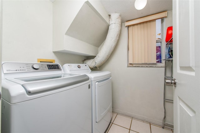 laundry area with light tile patterned flooring and washer and clothes dryer