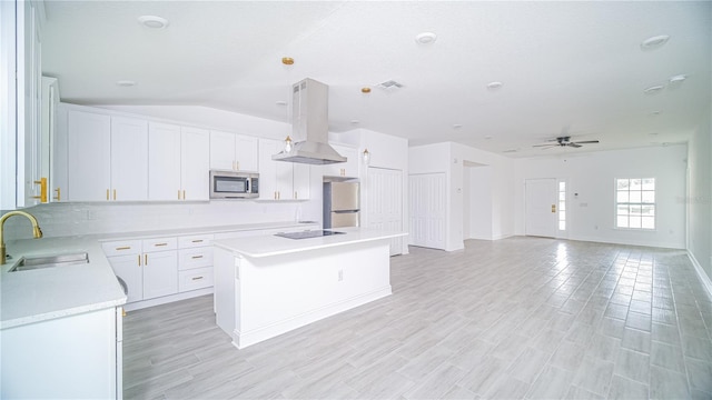 kitchen with a kitchen island, appliances with stainless steel finishes, island range hood, sink, and ceiling fan