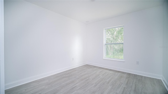 spare room featuring a healthy amount of sunlight and light hardwood / wood-style flooring