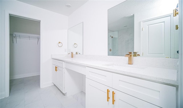 bathroom featuring a shower with door and vanity