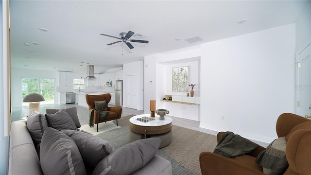 living room featuring light hardwood / wood-style flooring and ceiling fan