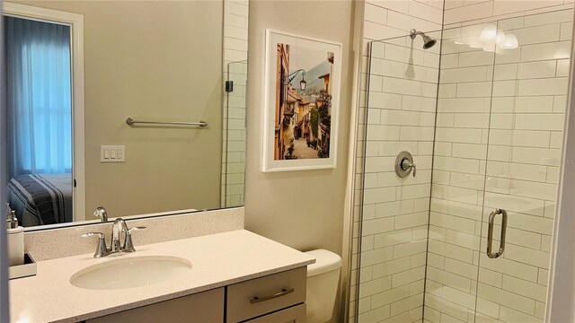 bathroom featuring vanity, an enclosed shower, and toilet