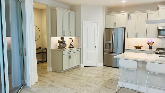 kitchen with white cabinets, appliances with stainless steel finishes, and decorative backsplash