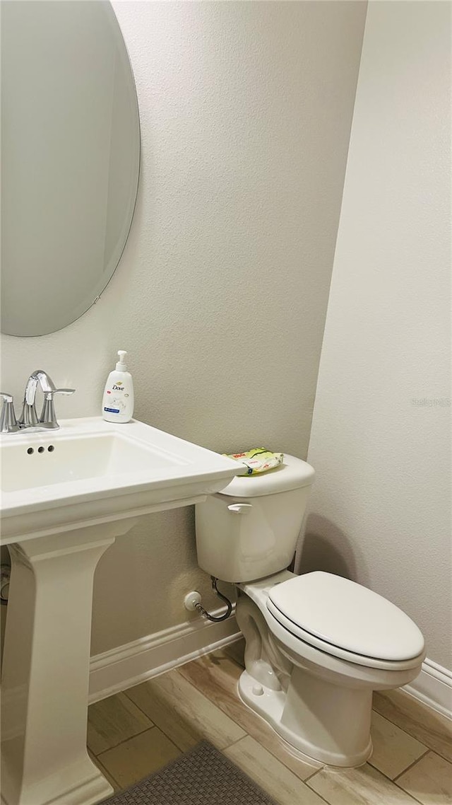 bathroom featuring hardwood / wood-style flooring and toilet