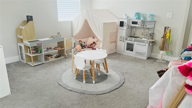 game room featuring light colored carpet and sink