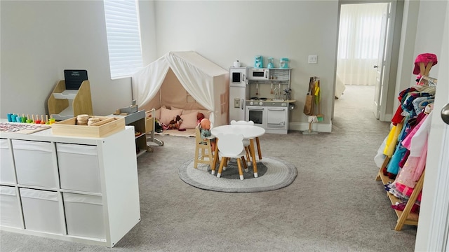 recreation room featuring light carpet