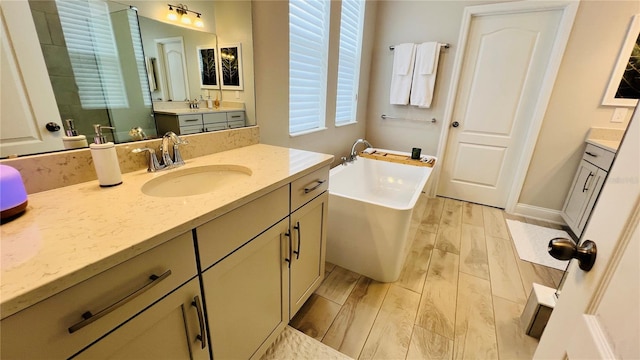 bathroom with a tub to relax in, vanity, and hardwood / wood-style flooring