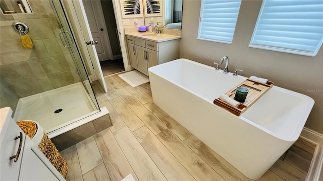 13706 Werrington Dr, Winter Garden, FL 34787 - bathroom featuring a freestanding tub, wood finished floors, a stall shower, and vanity