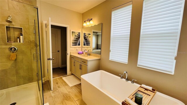 bathroom with vanity, hardwood / wood-style floors, and plus walk in shower