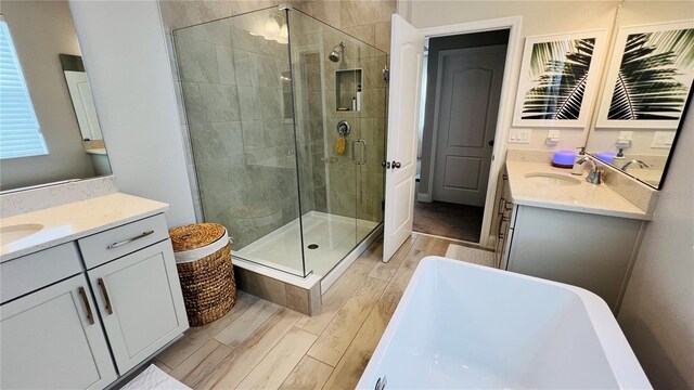 bathroom featuring shower with separate bathtub, vanity, and hardwood / wood-style flooring