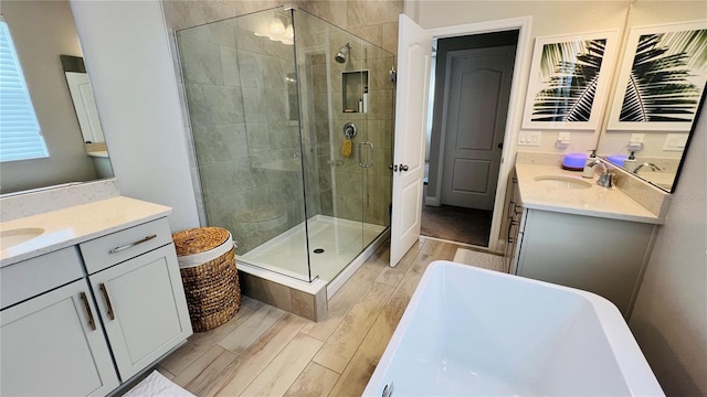 13706 Werrington Dr, Winter Garden, FL 34787 - full bath featuring wood finished floors, two vanities, a sink, a stall shower, and a freestanding bath