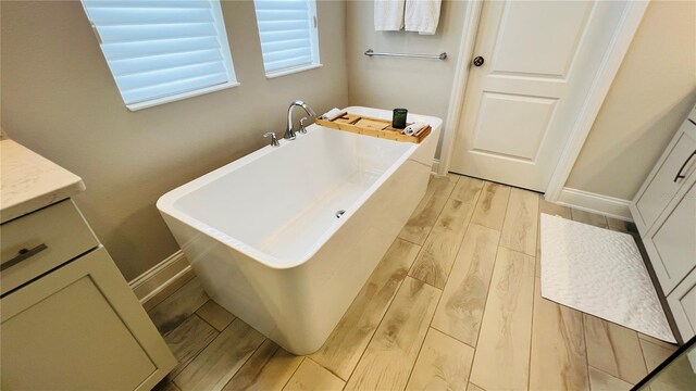 bathroom featuring a bathtub, vanity, and hardwood / wood-style flooring