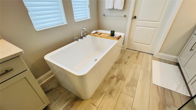 13706 Werrington Dr, Winter Garden, FL 34787 - full bathroom featuring a freestanding bath, vanity, baseboards, and wood tiled floor