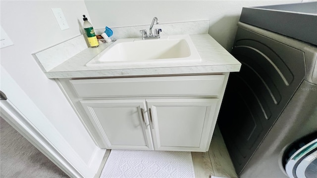 washroom featuring light tile patterned floors, washer / clothes dryer, and sink