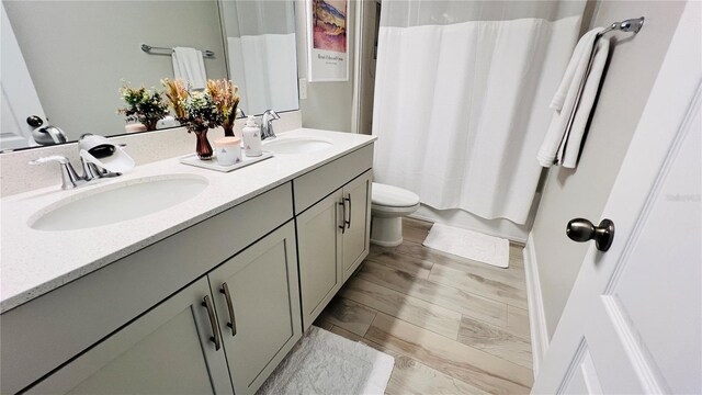 bathroom with curtained shower, toilet, vanity, and hardwood / wood-style floors