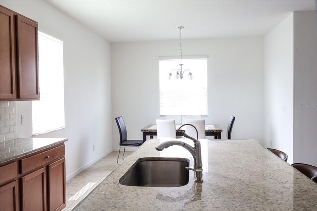 kitchen with stone counters, sink, and a healthy amount of sunlight