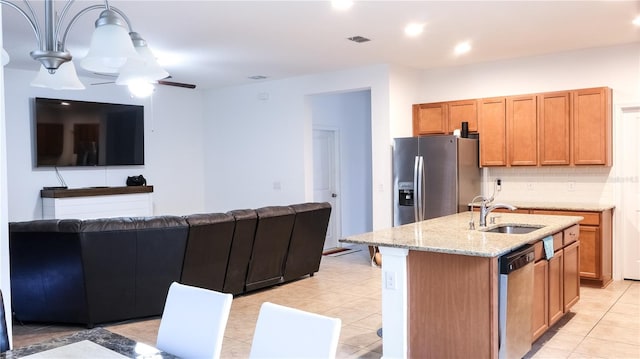 kitchen featuring ceiling fan, sink, a kitchen island with sink, backsplash, and stainless steel appliances