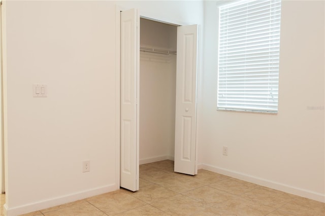 unfurnished bedroom with a closet and light tile patterned floors