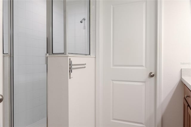 bathroom with vanity and a tile shower