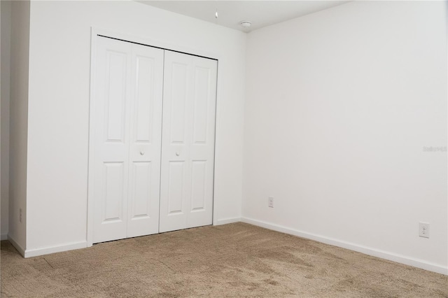 unfurnished bedroom featuring a closet and carpet flooring