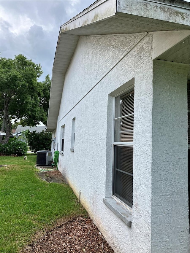 view of home's exterior with a yard and central AC