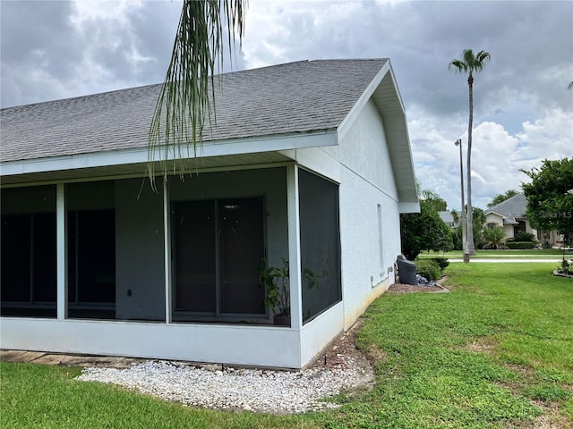 view of home's exterior featuring a sunroom and a lawn