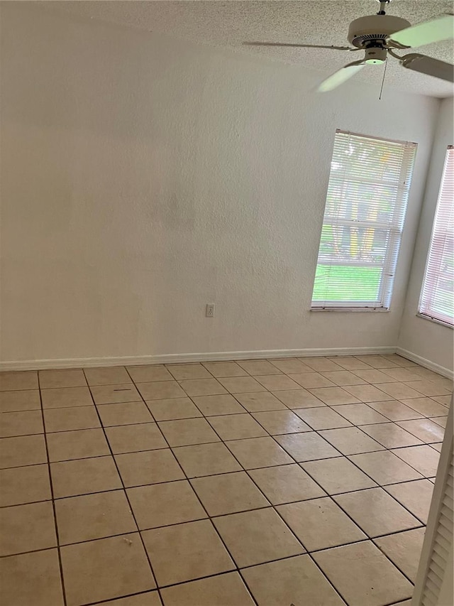 tiled spare room with ceiling fan and a textured ceiling