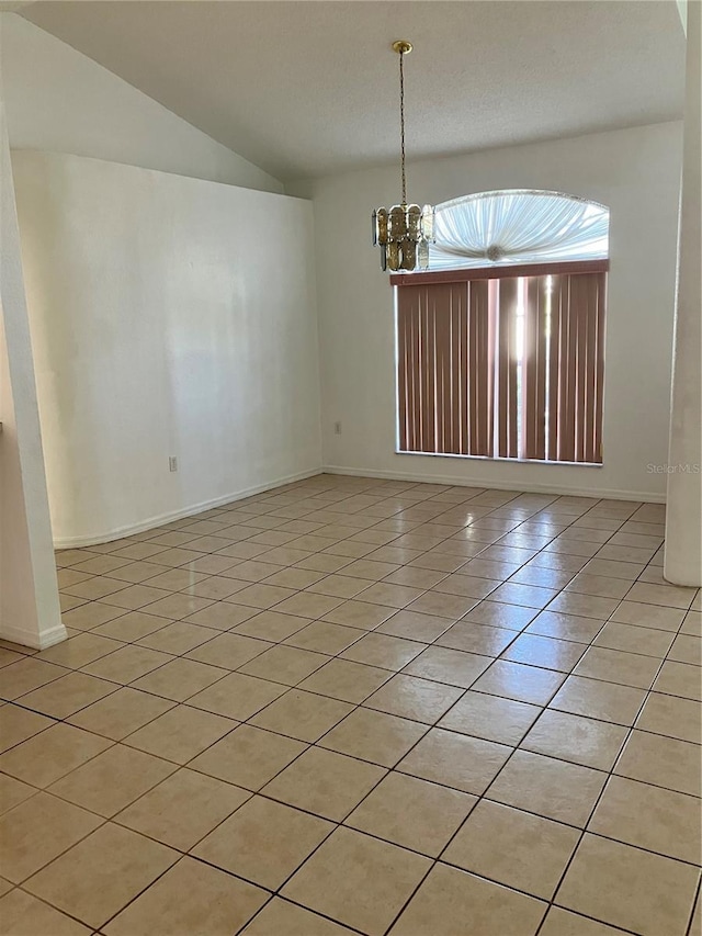 unfurnished room featuring a chandelier, light tile patterned floors, and lofted ceiling