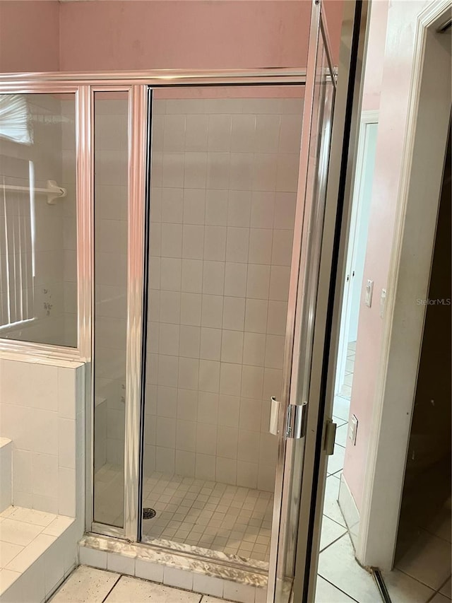 bathroom with tile patterned flooring and a shower with door