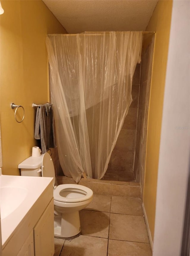 bathroom featuring tile patterned floors, toilet, a shower with curtain, vanity, and a textured ceiling