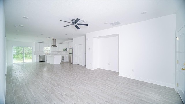 unfurnished living room with light hardwood / wood-style flooring and ceiling fan