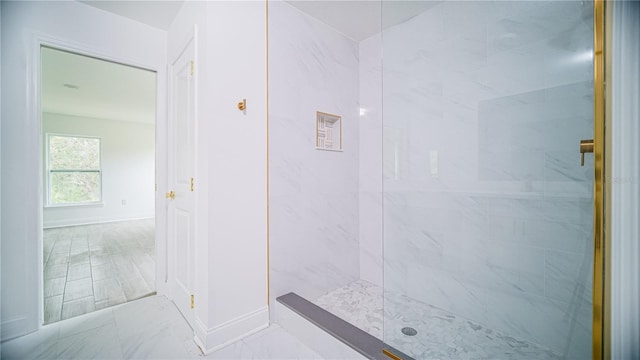 full bathroom featuring baseboards, marble finish floor, and a walk in shower