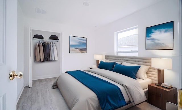 bedroom with a closet, visible vents, baseboards, and wood finished floors