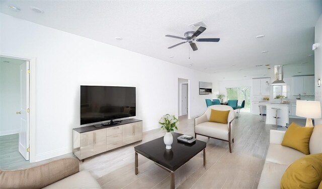 living room with light wood-type flooring and ceiling fan