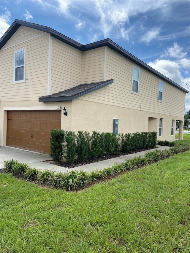 view of side of property with a garage and a lawn