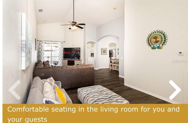 living room featuring ceiling fan, arched walkways, high vaulted ceiling, baseboards, and dark wood-type flooring
