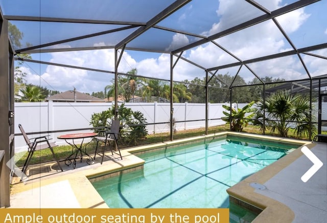 view of swimming pool featuring a patio and a lanai