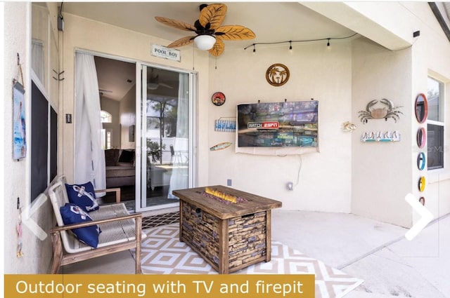 view of patio featuring ceiling fan and a fire pit